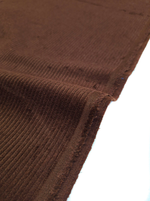 Close-up of brown corduroy texture on a white background