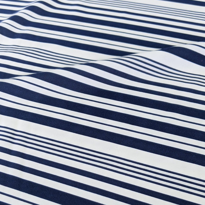 Close-up view of navy and white striped nylon spandex tricot fabric.